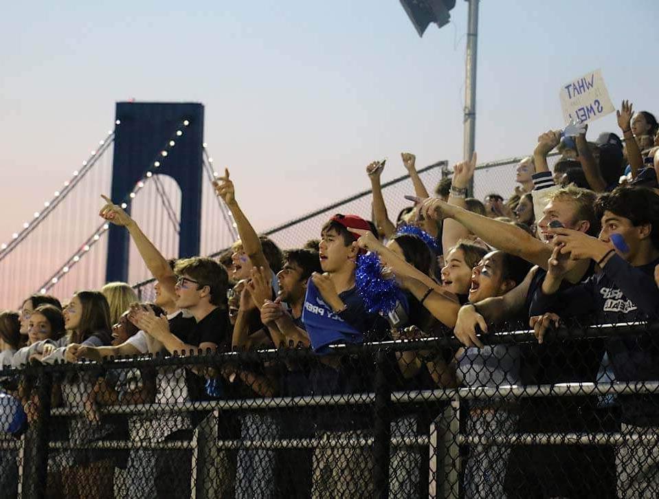 Crowds cheering on Blue Devil Night with bridge in background